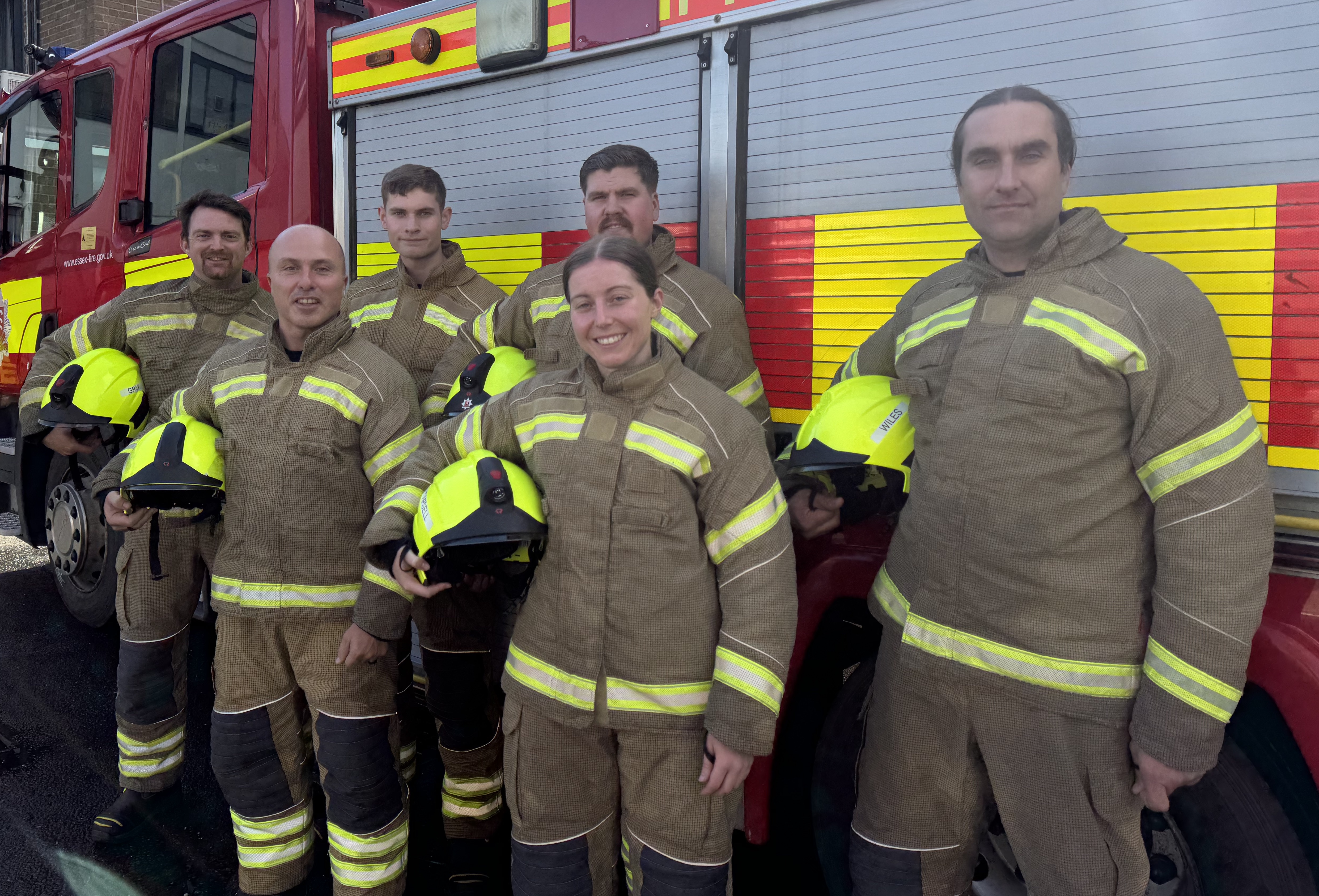 Six new on-call firefighters in front of a fire engine