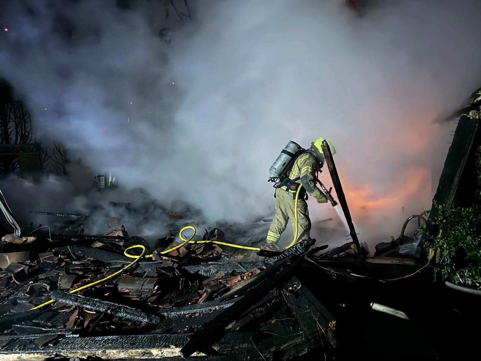 Firefighter extinguishing garage on fire