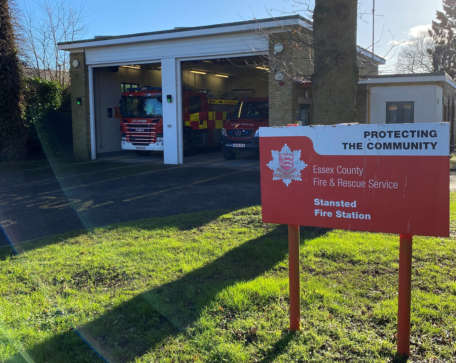 Stansted fire station in the background and a red sign with the name of the station in the foreground 