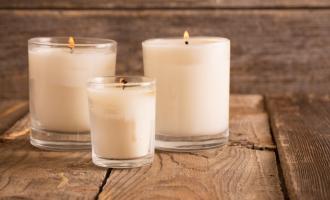 3 candles in glass holders on wooden table