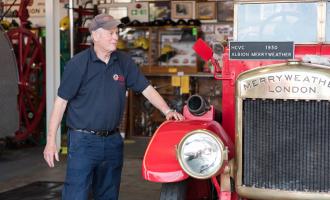 One of our museum volunteers looking after a red 1930s Merryweather fire engine.