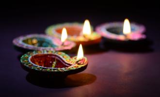 Four brightly coloured candles lit to celebrate Diwali