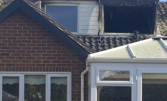 House fire, top floor window damaged by fire
