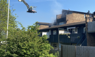 Firefighters using an Aerial Ladder Platform to extinguish a flat fire