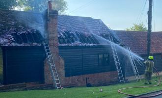 Firefighter spraying water at a barn conversion