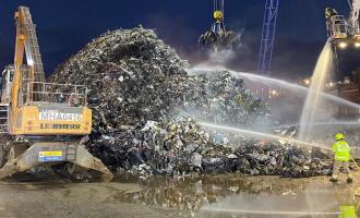 Firefighters working to extinguish a fire at a scrap metal yard