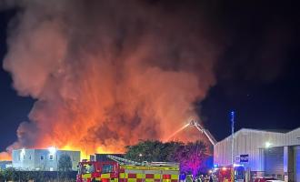 A plume of smoke, with a fire engine in the foreground