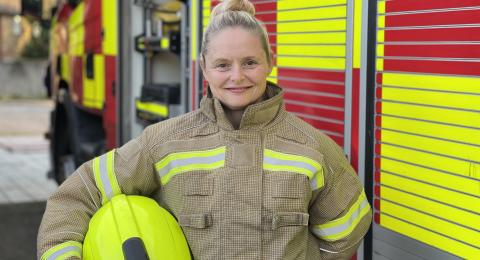 Firefighter Teresa Claxton standing in front of a fire engine