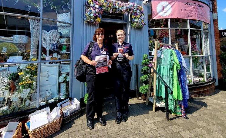 Two of our female protection officers in Rayleigh offering business advice. It's a sunny day and they are standing in front of a shop.