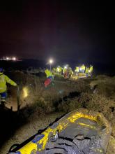 Firefighters and coastguard rescuing a man from the mud