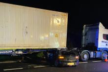 A car trapped under a lorry