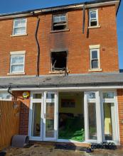 A three-storey terraced house with two windows burnt out