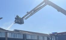Firefighters using an Aerial Ladder Platform to extinguish a roof fire