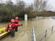 Firefighters walking through almost 4 ft of water to rescue a person trapped in their car