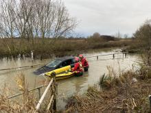 Firefighters walking through almost 4 ft of water to rescue a person trapped in their car