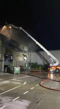 Firefighters using an Aerial Ladder Platform to extinguish a fire in an industrial unit